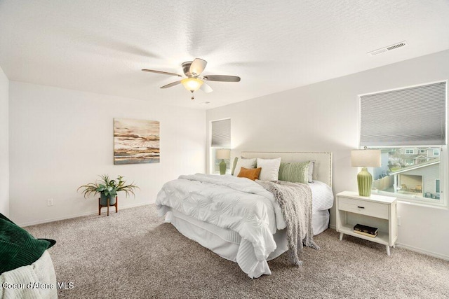 bedroom with a textured ceiling, ceiling fan, and carpet flooring