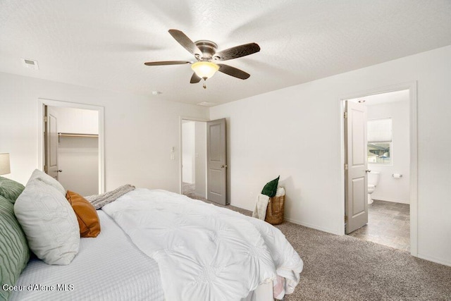 carpeted bedroom featuring ceiling fan, a walk in closet, a closet, and connected bathroom