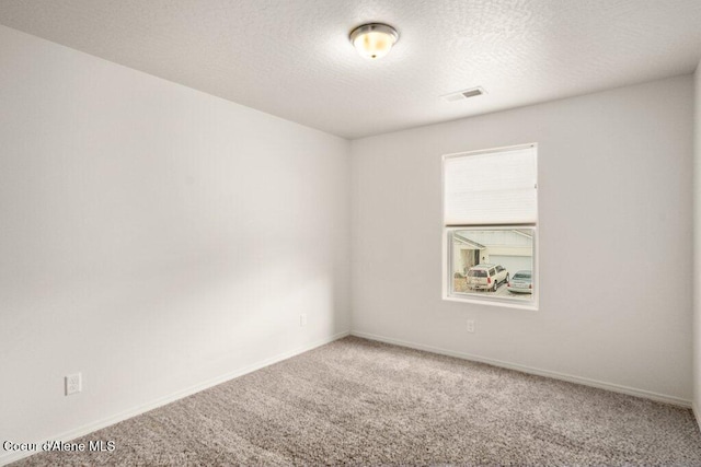 carpeted empty room with a textured ceiling