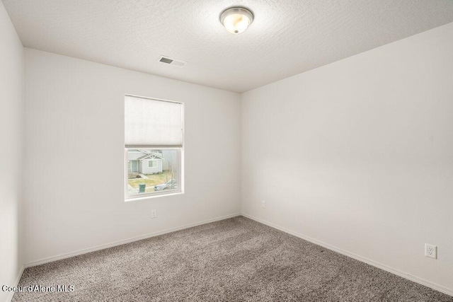 carpeted empty room with a textured ceiling