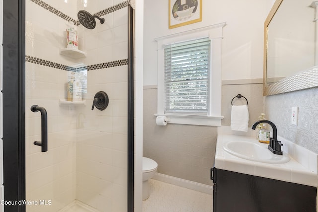 bathroom featuring toilet, a shower with door, and vanity