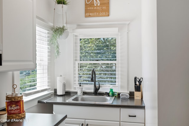 kitchen with white cabinets, a wealth of natural light, and sink