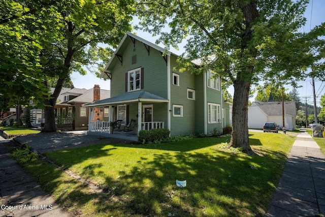 view of front of property featuring a front yard and covered porch