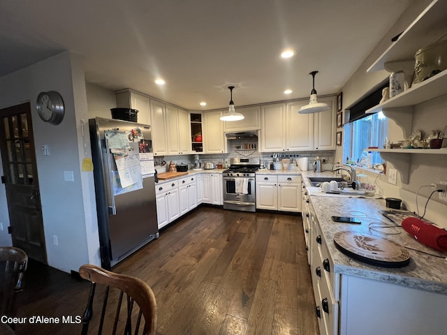 kitchen featuring decorative light fixtures, white cabinetry, dark hardwood / wood-style floors, light stone countertops, and appliances with stainless steel finishes