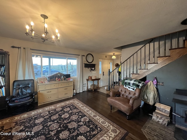 living room with a textured ceiling, a notable chandelier, and hardwood / wood-style floors