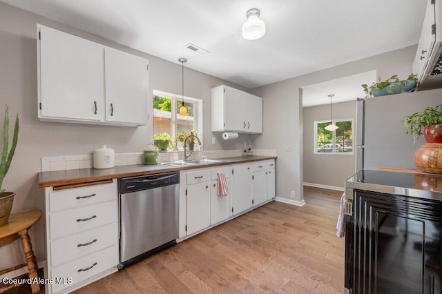 kitchen featuring white cabinetry, sink, decorative light fixtures, and dishwasher