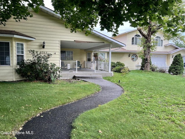 view of front of house with a garage, covered porch, and a front lawn