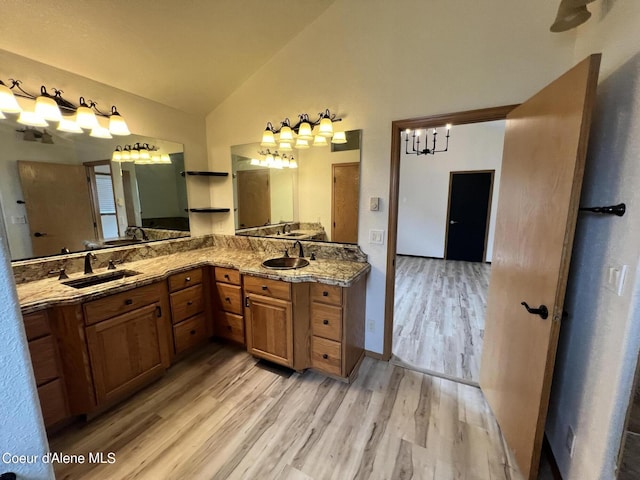 bathroom featuring lofted ceiling, vanity, and wood-type flooring