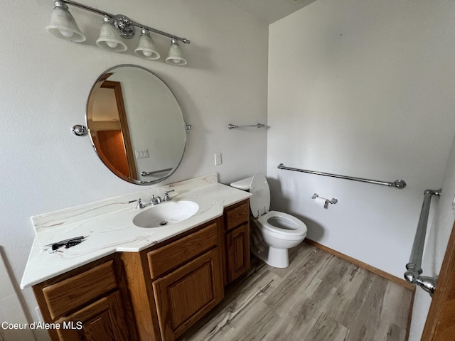 bathroom featuring toilet, vanity, and wood-type flooring