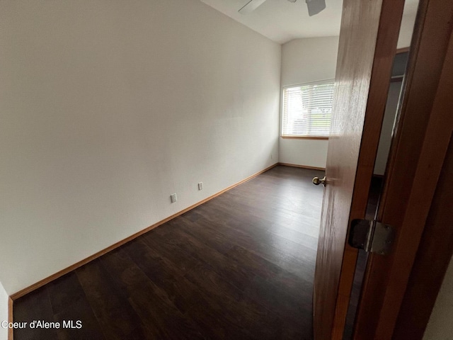 empty room with ceiling fan, lofted ceiling, and dark hardwood / wood-style floors