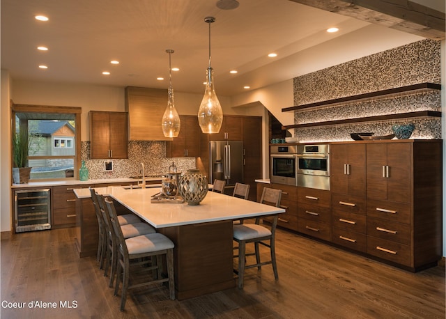 kitchen featuring pendant lighting, a breakfast bar, a large island with sink, wine cooler, and stainless steel appliances