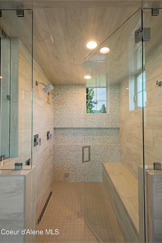 bathroom with tile patterned floors and a shower with door