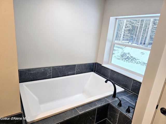 bathroom with a relaxing tiled tub