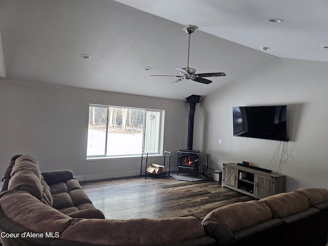 living room featuring lofted ceiling, hardwood / wood-style floors, ceiling fan, and a wood stove