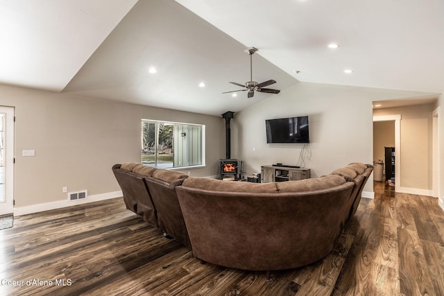 living area with baseboards, visible vents, lofted ceiling, a wood stove, and dark wood-style flooring