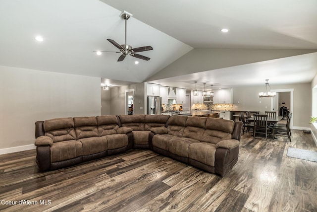 living room featuring baseboards, recessed lighting, ceiling fan with notable chandelier, dark wood-style floors, and lofted ceiling
