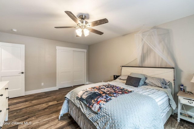 bedroom with baseboards, ceiling fan, a closet, and dark wood-type flooring