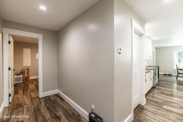 corridor with dark wood-type flooring, recessed lighting, and baseboards