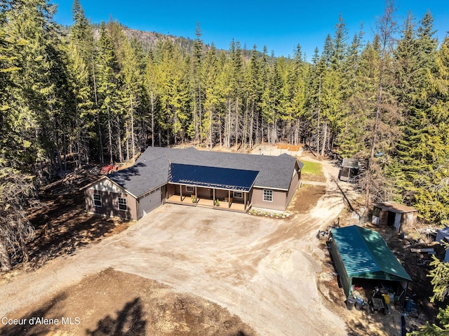 birds eye view of property featuring a forest view
