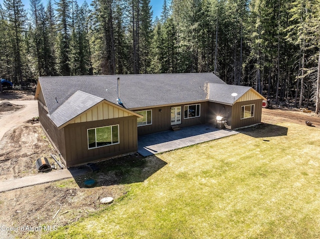 view of front of property with a front yard, a patio area, french doors, and roof with shingles