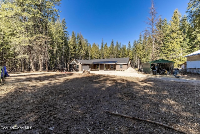 view of front of property with a wooded view