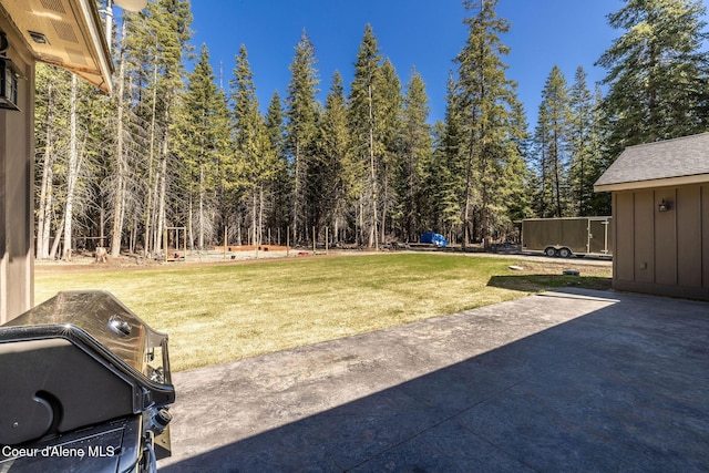 view of yard featuring a patio and a wooded view