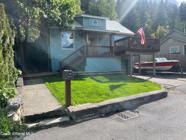 view of front facade with a wooden deck and a front yard