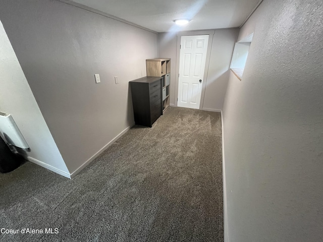 corridor featuring dark colored carpet