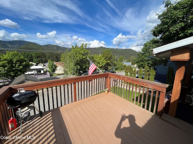 wooden deck featuring a mountain view and a grill