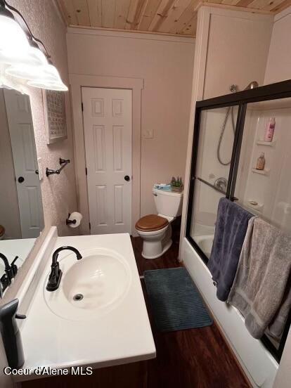 full bathroom with wood ceiling, vanity, shower / bath combination with glass door, hardwood / wood-style flooring, and toilet