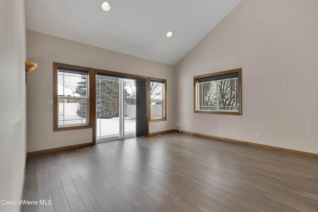 spare room featuring hardwood / wood-style floors and high vaulted ceiling