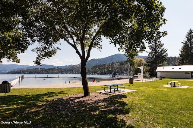 view of community with a yard and a water and mountain view