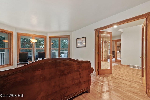 living room with french doors and light wood-type flooring