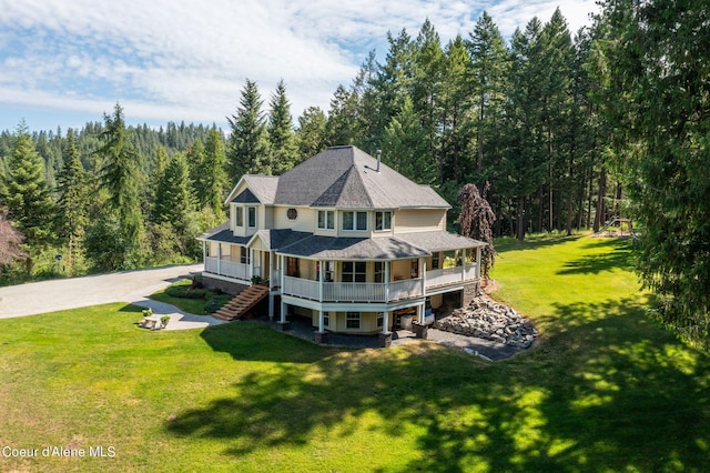 back of property featuring a porch and a yard