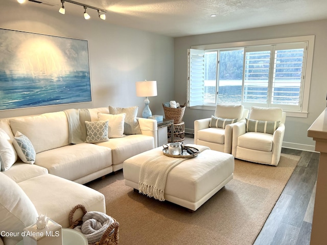 living room with a textured ceiling and dark hardwood / wood-style floors