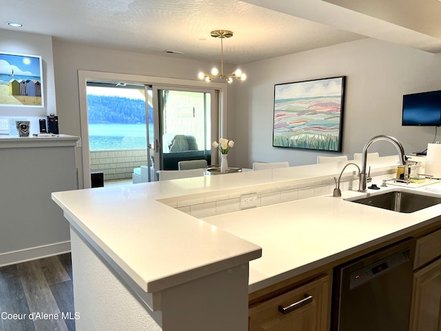 kitchen featuring dishwasher, sink, hanging light fixtures, an inviting chandelier, and dark hardwood / wood-style floors