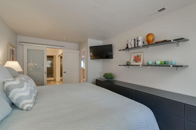 bedroom with hardwood / wood-style flooring and a textured ceiling