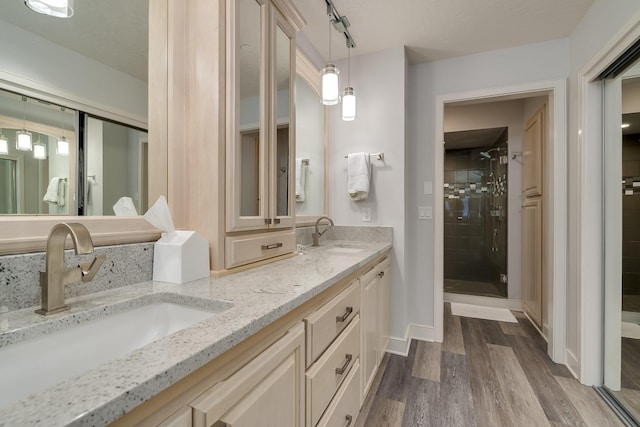 bathroom with hardwood / wood-style floors, vanity, and an enclosed shower