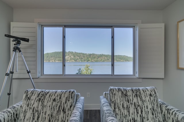 living area featuring a water view, hardwood / wood-style flooring, and a healthy amount of sunlight