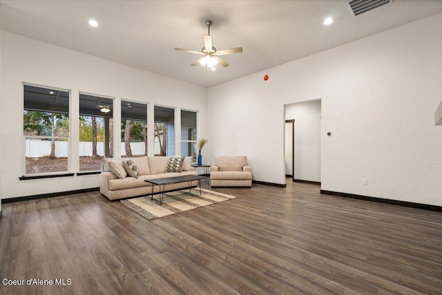 unfurnished living room featuring ceiling fan and dark wood-type flooring