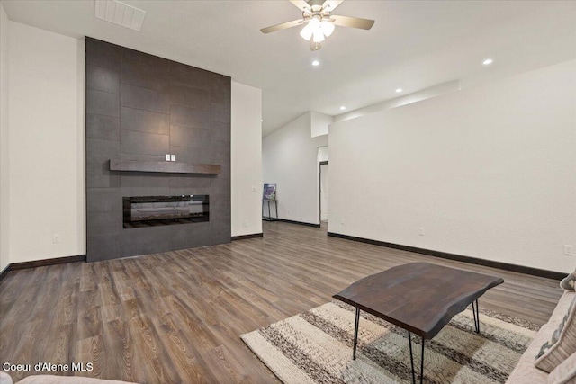 unfurnished living room with a fireplace, hardwood / wood-style flooring, ceiling fan, and lofted ceiling