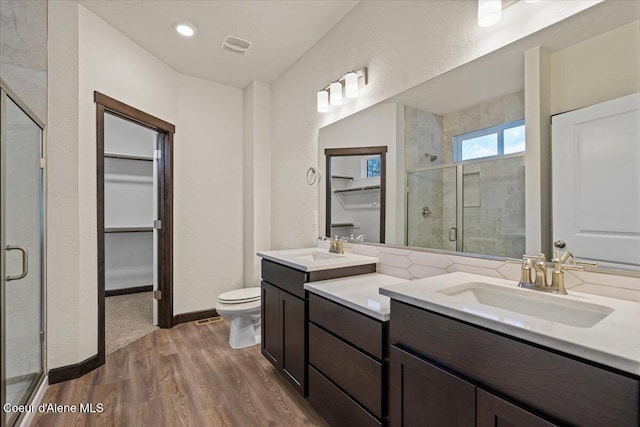 bathroom with vanity, toilet, wood-type flooring, and walk in shower