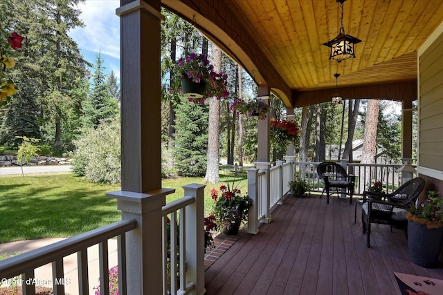 wooden deck with a yard and covered porch