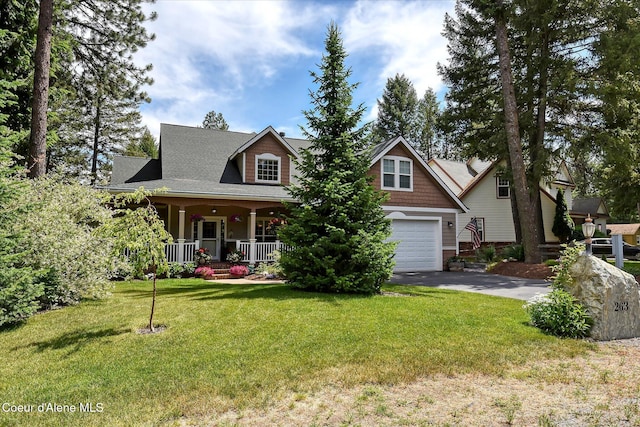 view of front of property with a porch, a garage, and a front lawn