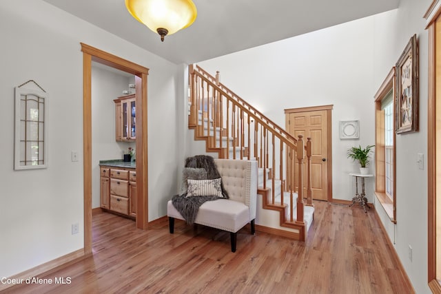 foyer with light hardwood / wood-style floors and bar area