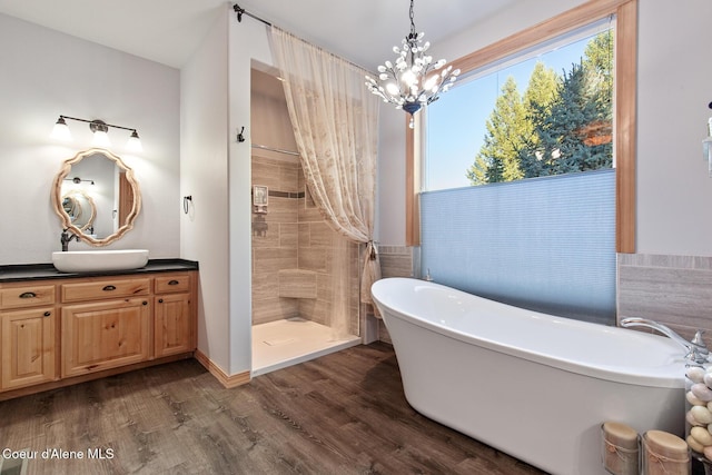 bathroom featuring vanity, plus walk in shower, a chandelier, and wood-type flooring