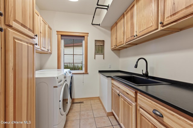 laundry area featuring cabinets, light tile patterned floors, washer and clothes dryer, and sink