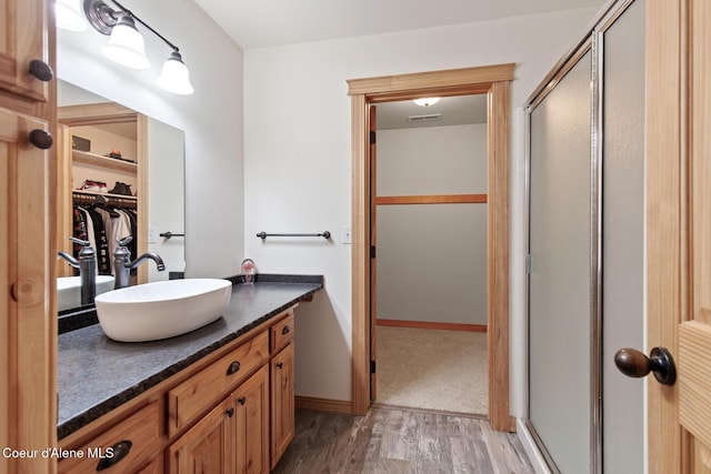 bathroom with vanity, wood-type flooring, and a shower with door