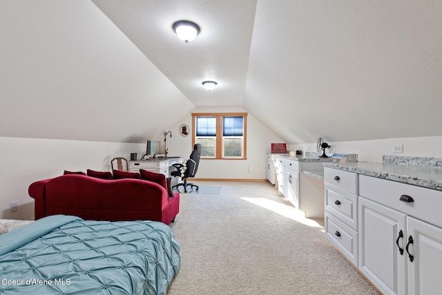 carpeted bedroom featuring a textured ceiling and vaulted ceiling