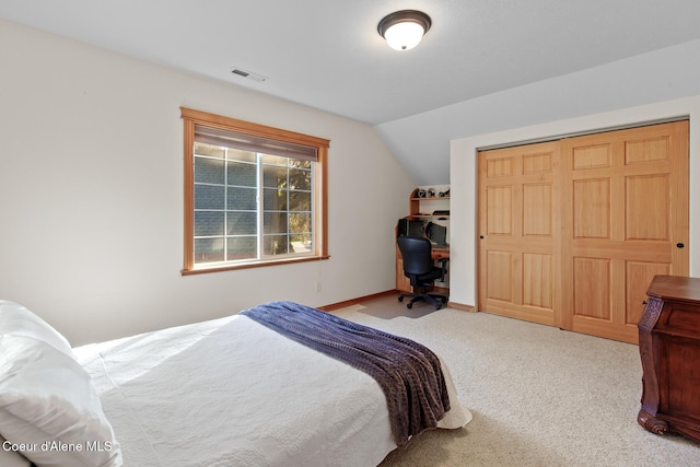 carpeted bedroom featuring vaulted ceiling and a closet